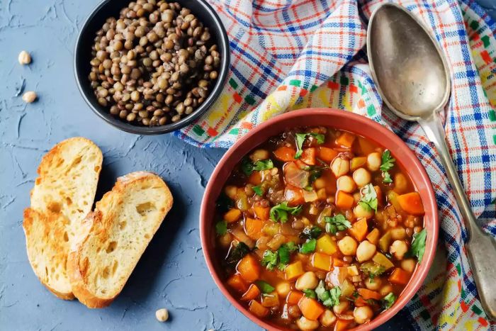 Moroccan-spiced green lentil and chickpea soup, set against a stone backdrop. Toning effect applied. Focus on select details.