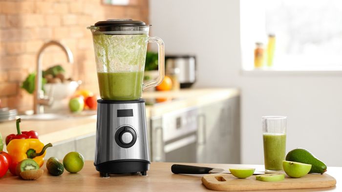 A blender filled with a vibrant green smoothie.