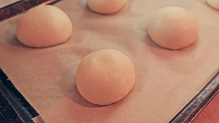 Raw dough balls arranged on a baking sheet.