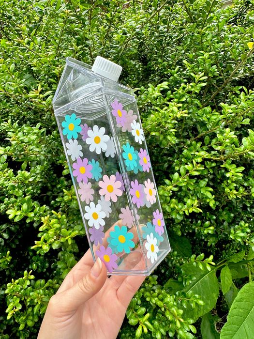 A model holding the milk carton adorned with colorful flowers, adding charm to the moment.