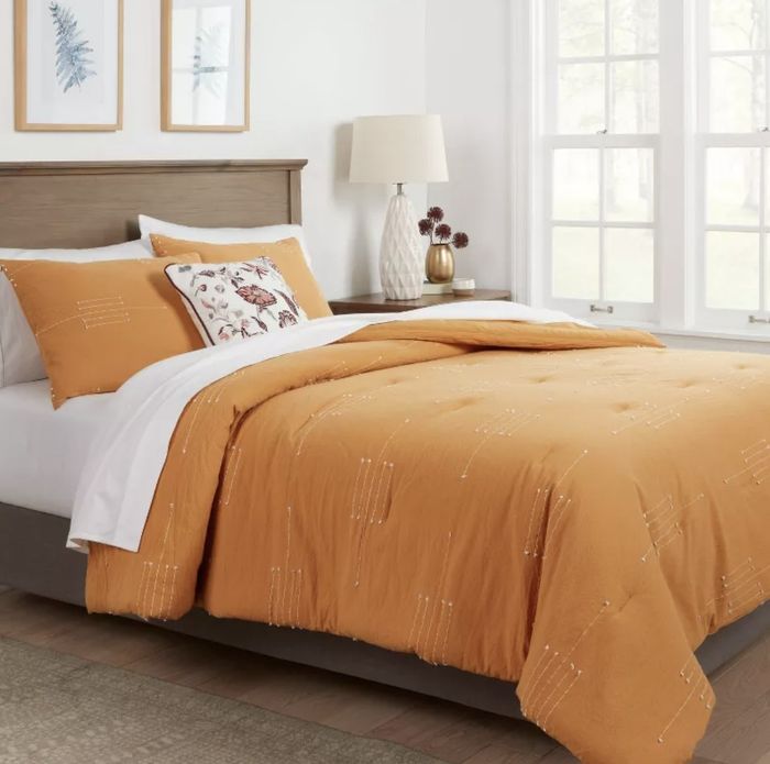 A mustard-colored comforter set with matching shams.