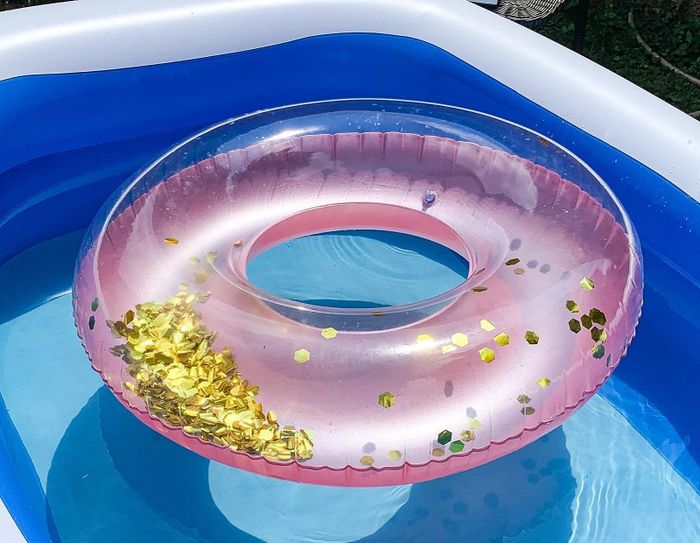 The reviewer's pink floatie floating in the pool