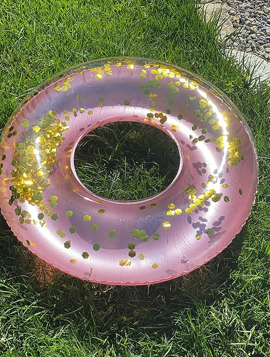 A pink floatie from the reviewer resting on the grass.