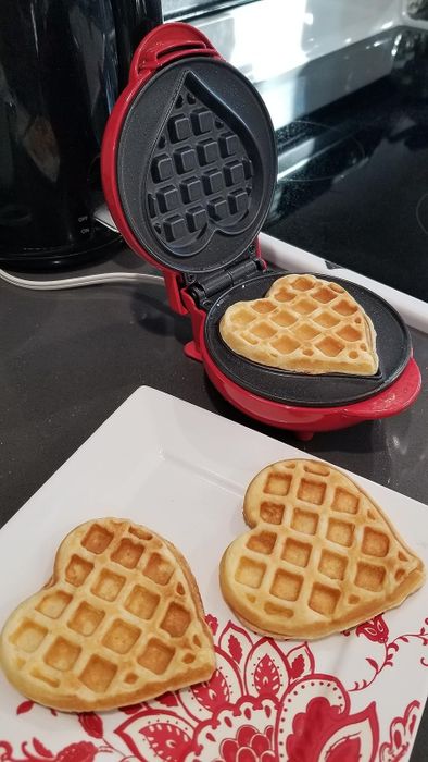 The reviewer's waffle maker with heart-shaped waffles inside