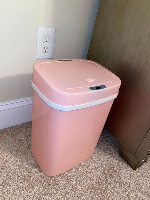 The pink trash can with the lid closed.