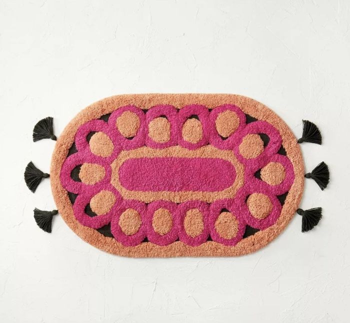 An orange, pink, and black bath rug