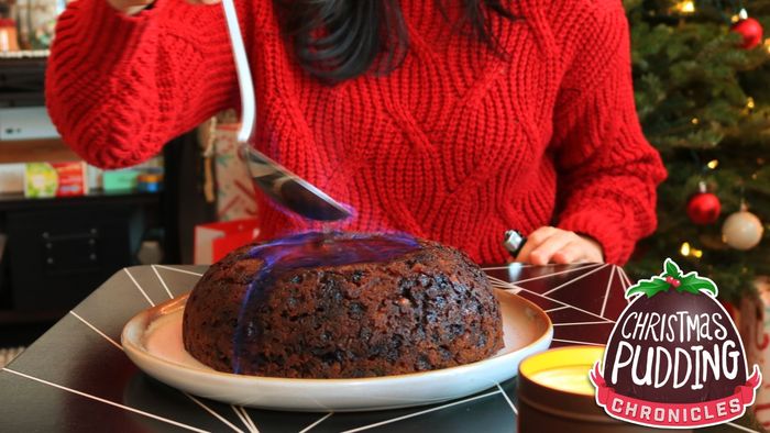 Allie lighting up a Christmas pudding with flames.