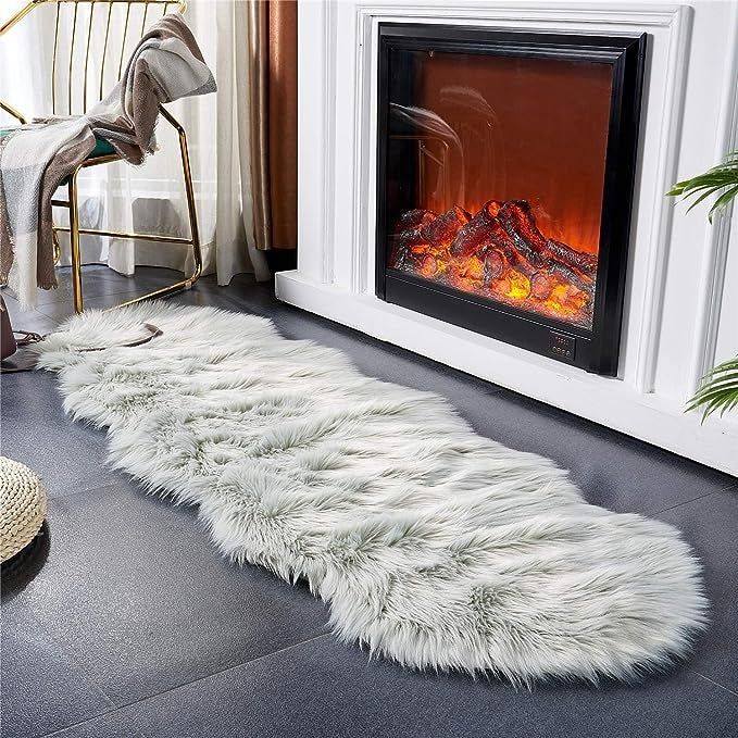 Grey rug positioned near a fireplace
