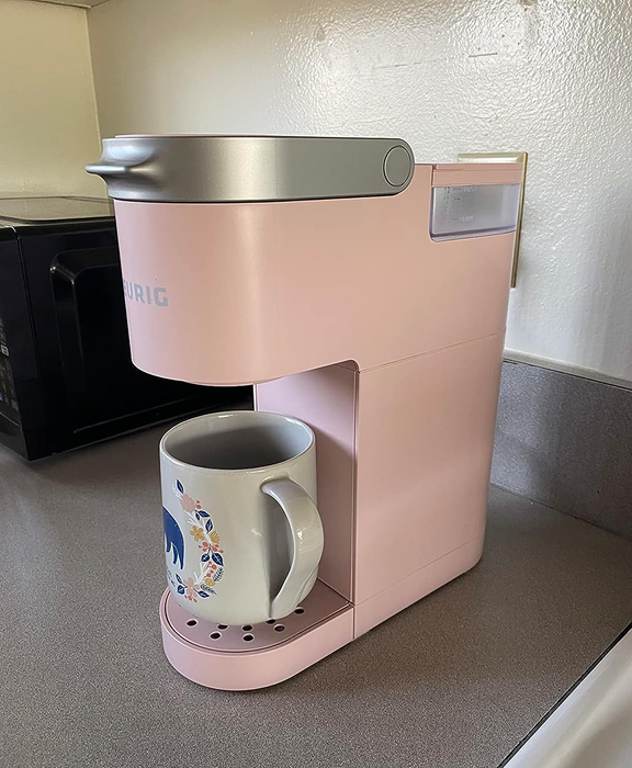 A pink Keurig from the reviewer, accompanied by a coffee mug.