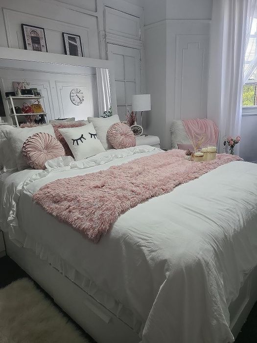 A pink blanket from the reviewer placed on white bedding.