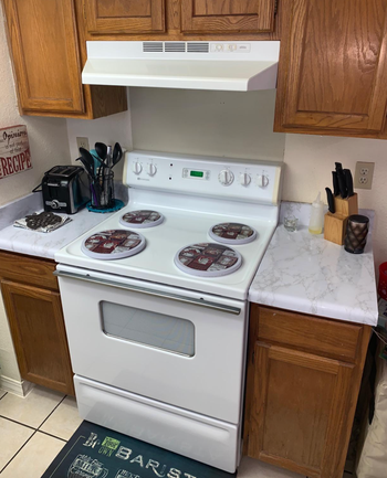 A reviewer's photo showcasing white marble adhesive applied to kitchen counters