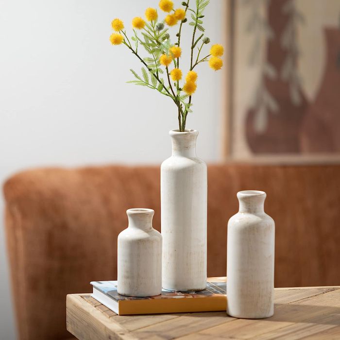 A set of three white cylindrical vases in varying sizes