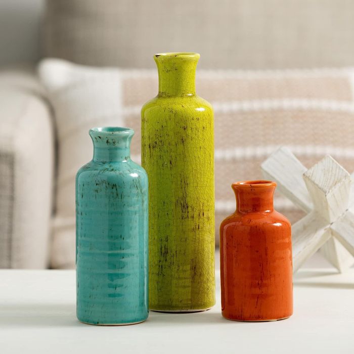 The same set featuring orange, blue, and green vases