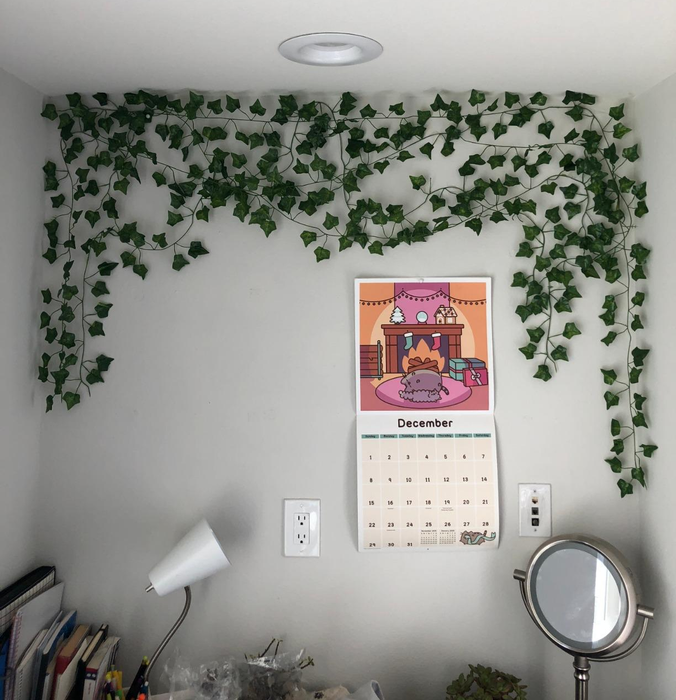 Artificial green ivy cascading along the top of a bedroom wall