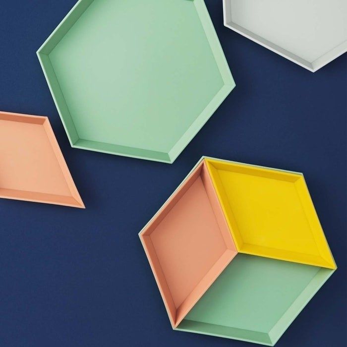 Geometrically designed trays in soft shades of pink, yellow, green, and white.