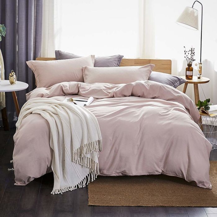 A soft lavender duvet cover and matching pillows resting on a bed