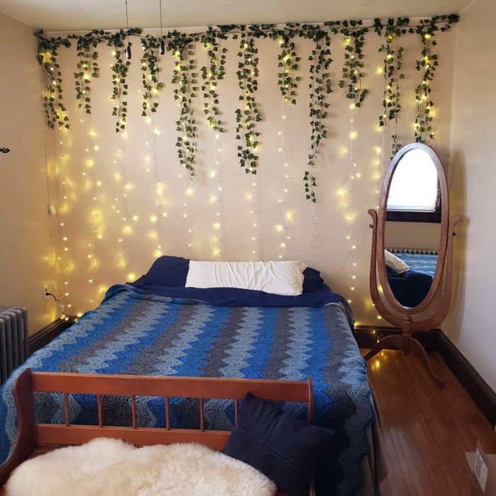 A collection of ivy vines placed behind a bed for a touch of greenery.