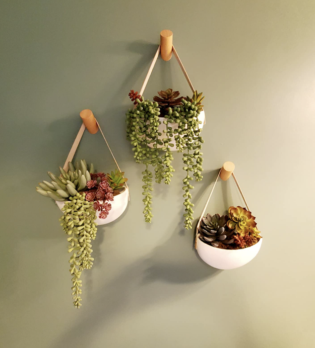 Wooden wall hooks mounted on a wall, with bags and accessories hanging from them.