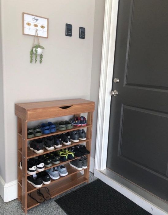 The wooden shoe rack showcased in a reviewer's living space