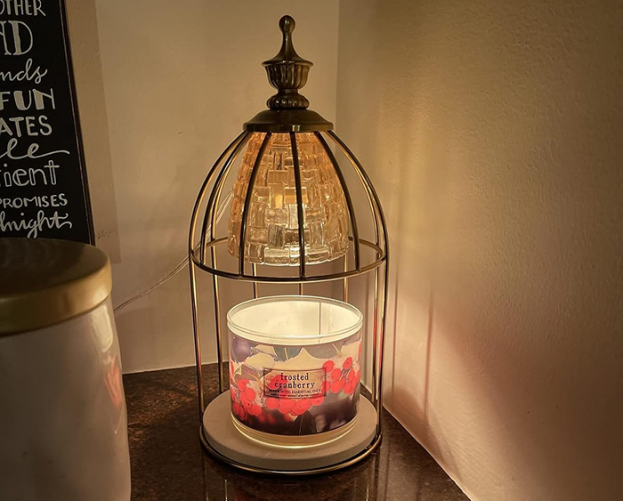 A candle resting inside a candle warmer on a table