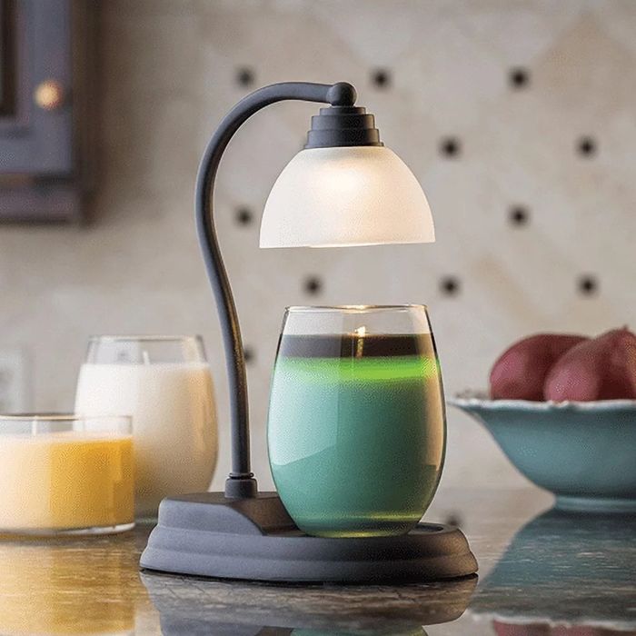 The candle warmer featuring a sleek scroll design with a frosted white glass shade