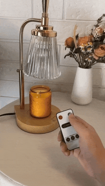 A reviewer using the remote to activate the candle warmer