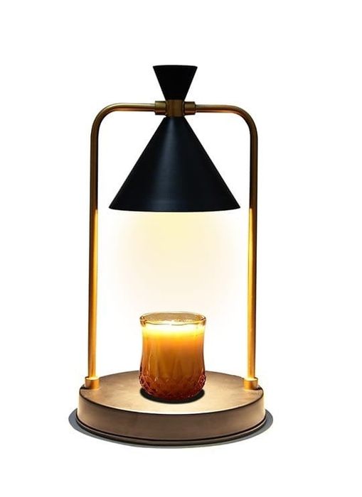 A stylish candle warmer lamp featuring a sleek design, complete with a remote control and additional bulbs, perfect for creating a cozy ambiance in any room