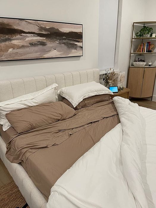 A reviewer’s tan and white sheets neatly arranged on a bed.