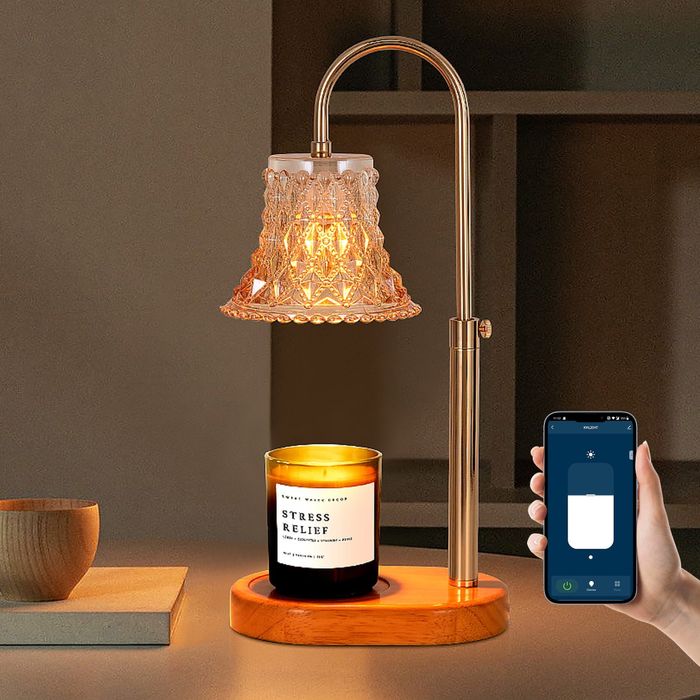 Candle warmer beside a model’s hand holding a smartphone with the linked app