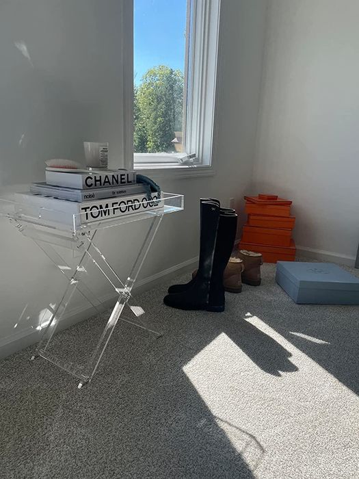 The reviewer's lucite tray table is displayed with various objects and books arranged neatly on top.