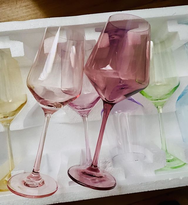 The reviewer showcases the different colors of the wine glasses, highlighting their delicate pastel shades.