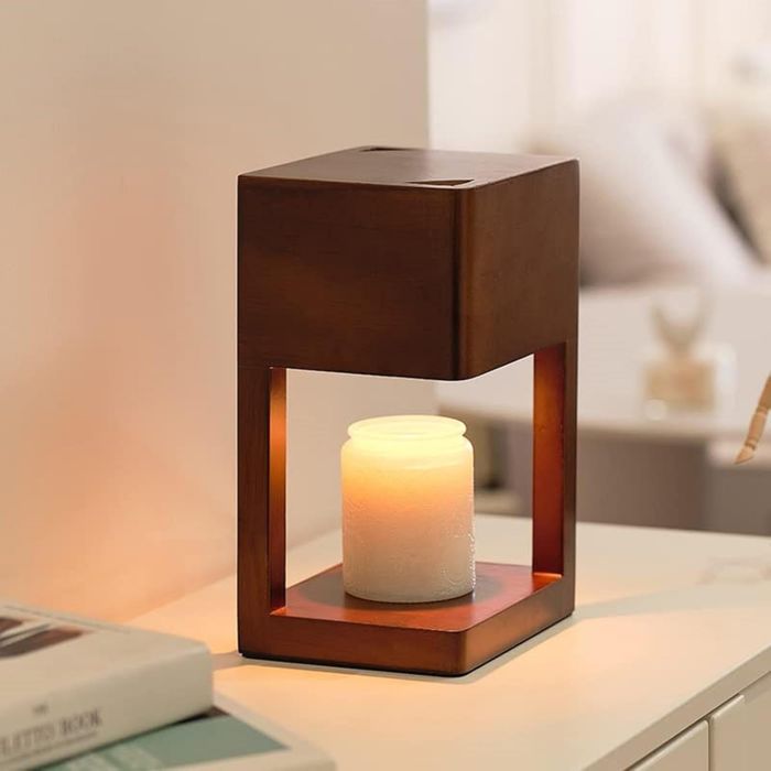 An electric candle warmer lamp placed on a desk within a cozy room, perfect for enhancing the decor and setting a peaceful atmosphere.