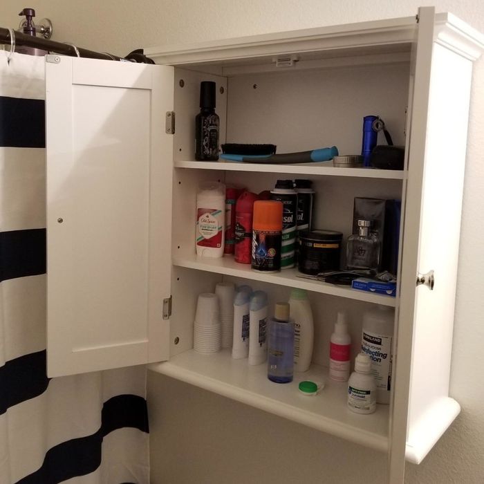 A reviewer’s photo of the medicine cabinet with the doors open, showing the inside storage