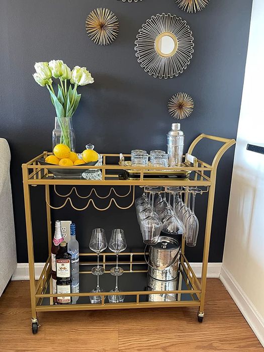A reviewer’s photo of the rolling bar cart with glasses, alcohol, fruit, and flowers