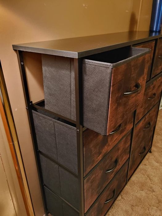 A reviewer's photo showcasing an open drawer of the rustic brown storage unit
