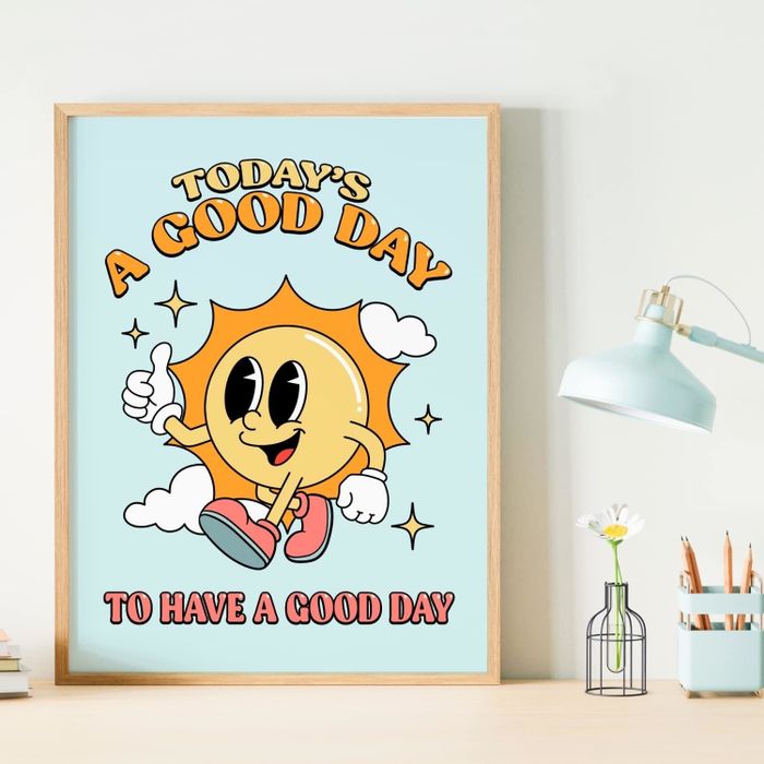 A framed print showcasing a cheerful cartoon sun character giving a thumbs-up, surrounded by clouds and stars, with the message: