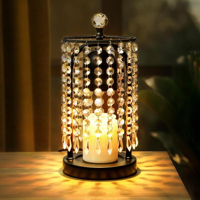 A candle holder placed on a table with a candle inside