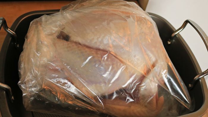 A raw turkey inside a roasting bag.