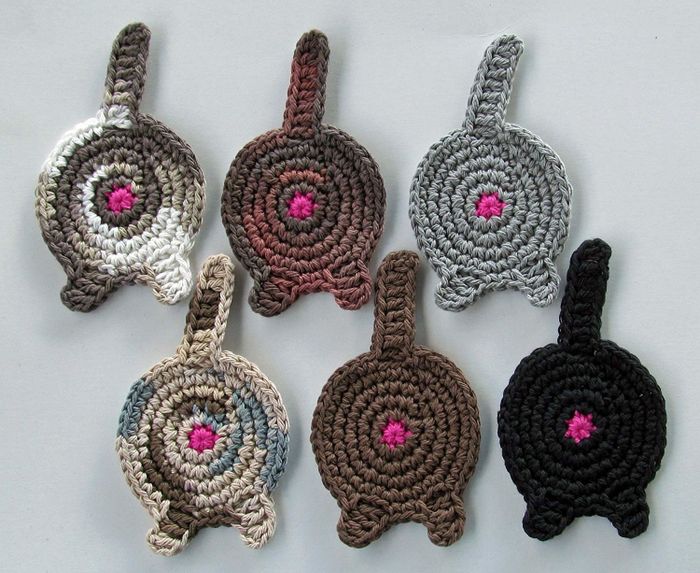 A collection of crocheted cat butt coasters.