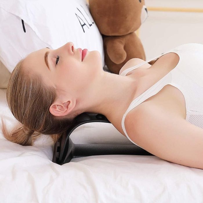 A model using the Magic Back Stretcher Lumbar Support Device to relieve neck tension.
