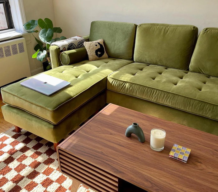 Close-up of the green couch in a cozy living room
