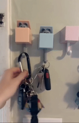 A reviewer demonstrating the fun of placing and removing keys from the hooks, showing the adorable mice and cats popping out.