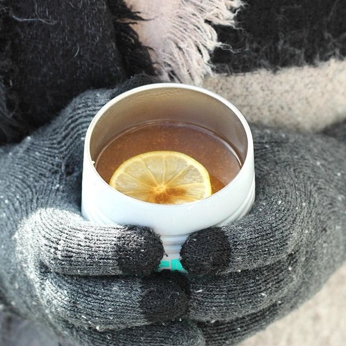 A person enjoying a hot cup of Mulling Spice Cocktail.