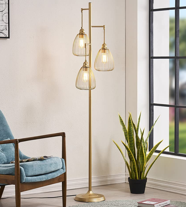 The golden tree lamp glowing in a stylish living room setting.