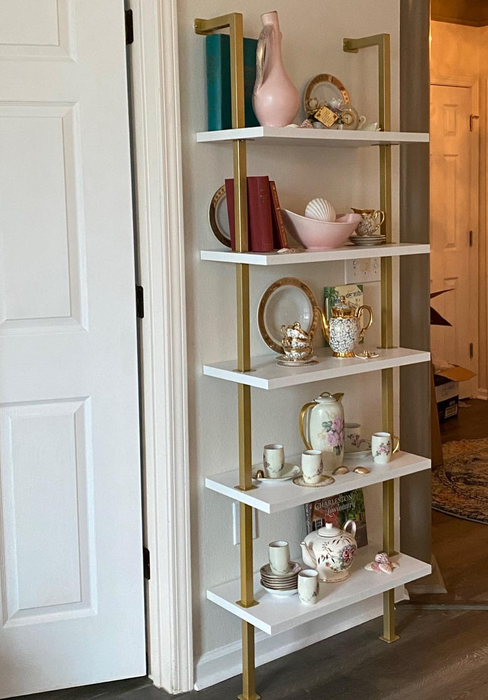 Reviewer image of the gold and white bookshelf showcasing various decorative items