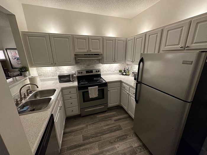 The reviewer's kitchen, featuring lights mounted both under and on top of the cabinets. The lights themselves are concealed, with only their soft illumination visible.