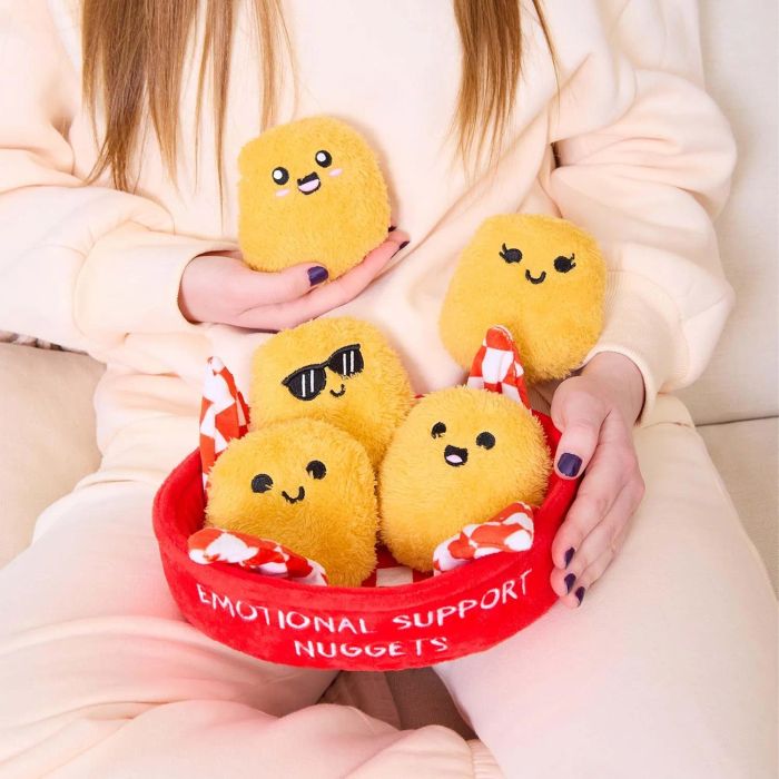 A woman holding a plush toy in the shape of nuggets with a red background