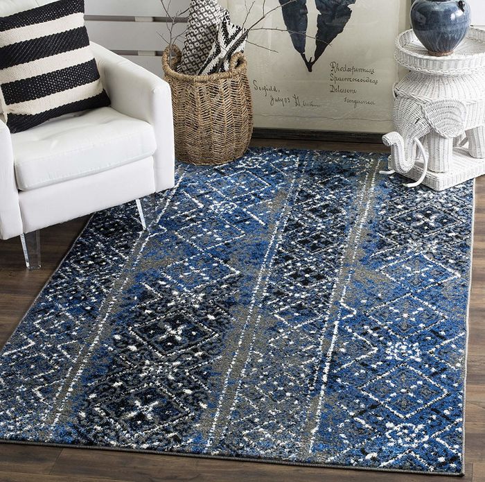 A blue and grey rug with a diamond and dot pattern, featuring white accents.