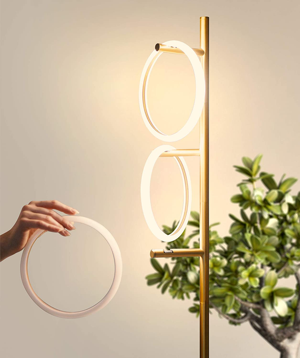 A model adjusting one of the illuminated rings on the branches of the floor lamp.
