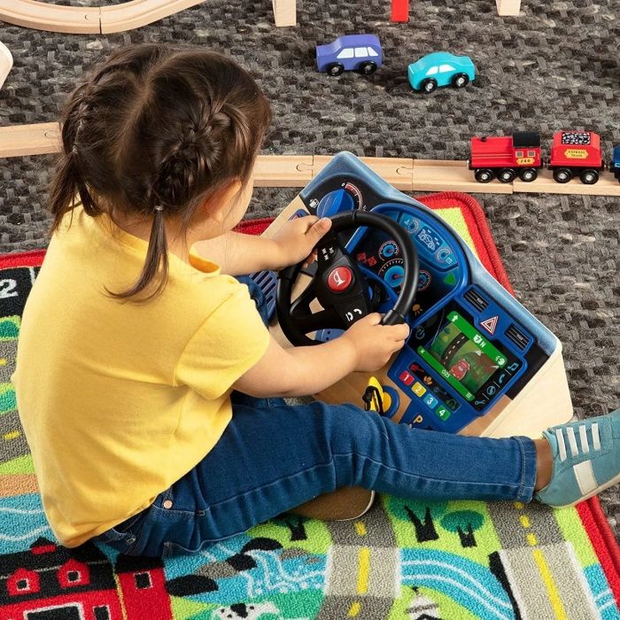 A child sitting on the floor, enjoying playtime with the dashboard toy